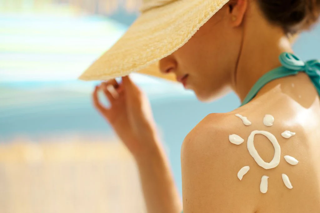 a women wearing a hat and summer outfit soaking in sunlight.